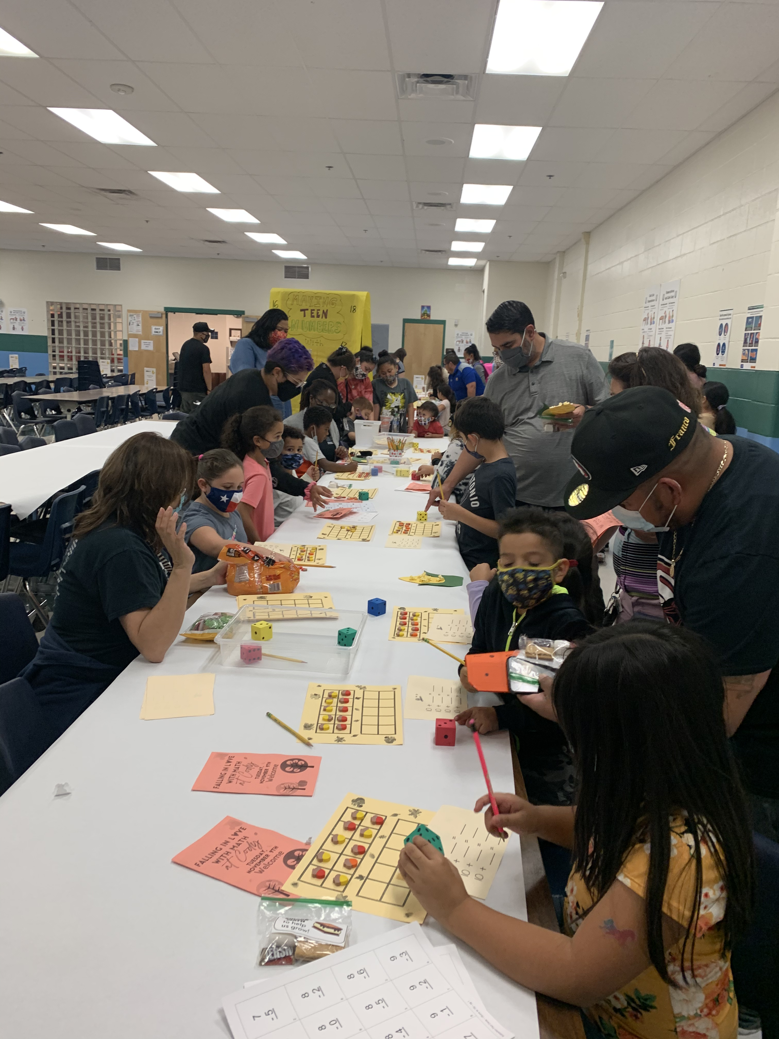 Crowd of parents and students playing Math games in the school cafeteria.