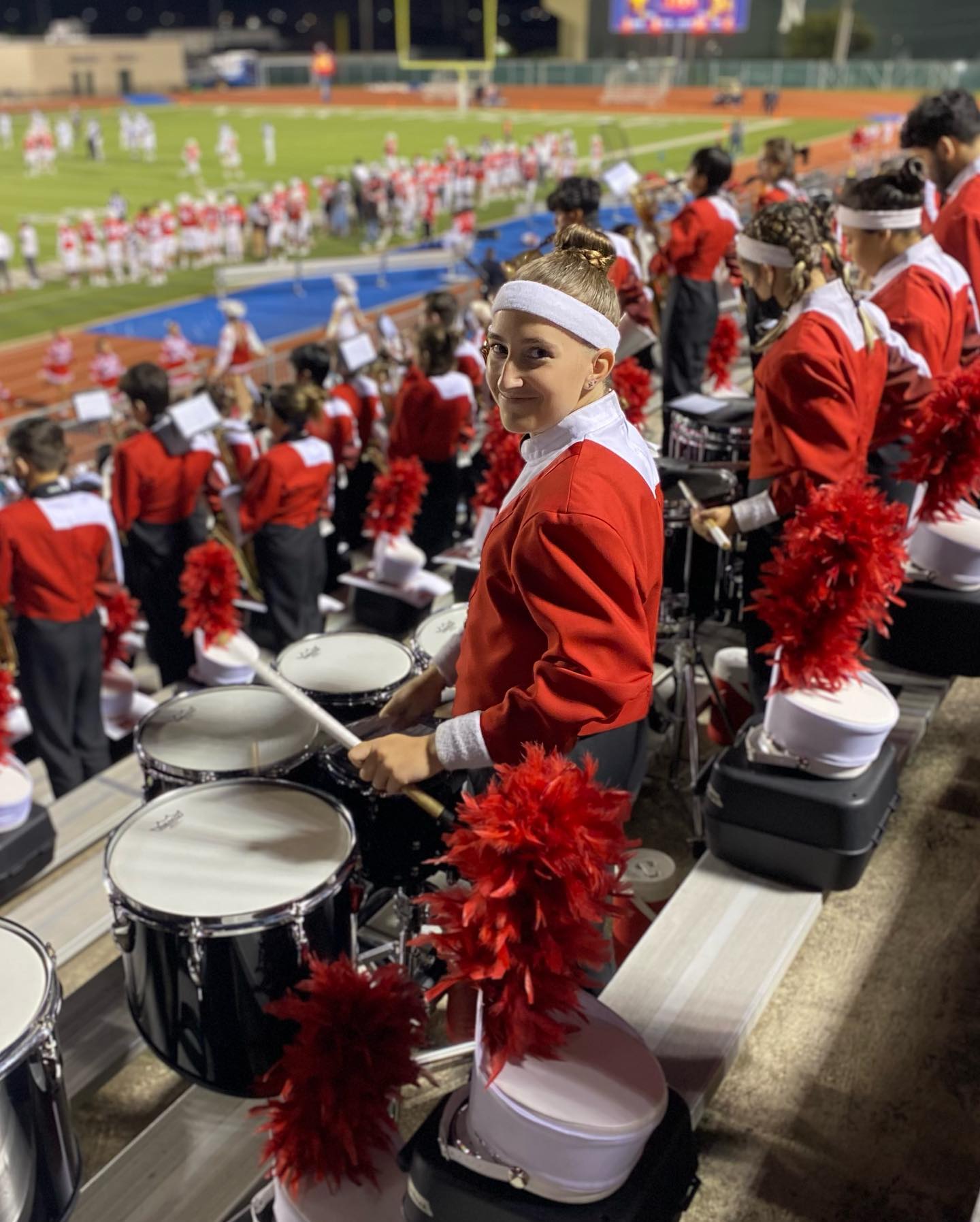 Taft band student standing on bleachers with drums at football game
