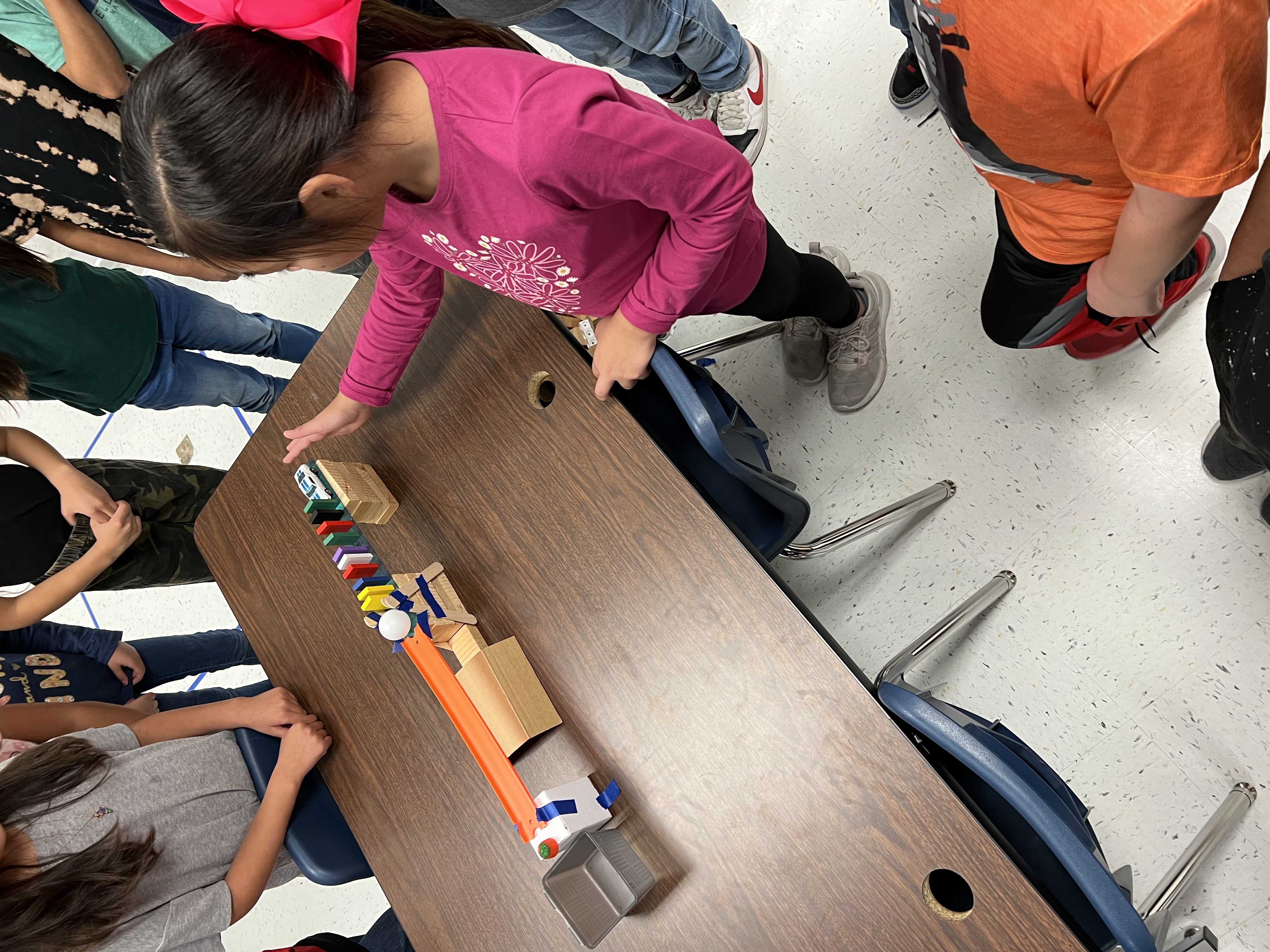 Student working with different STEM items to create a ramp