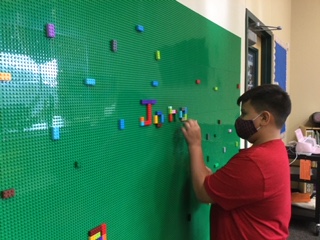 Student in front of a Lego wall