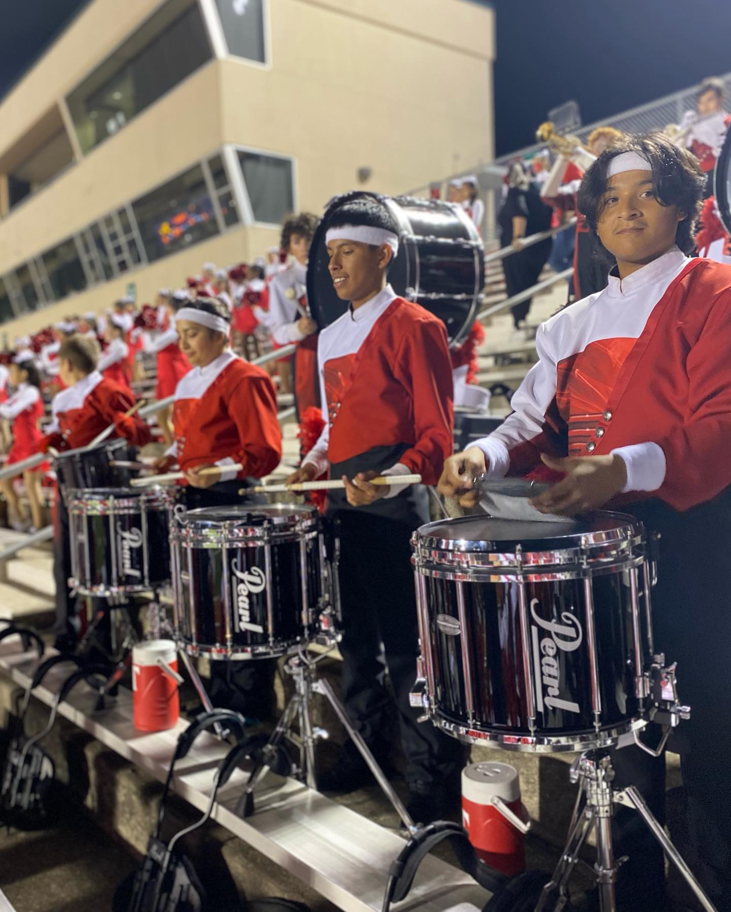 Taft band drumline students standing on bleachers with drums at football game