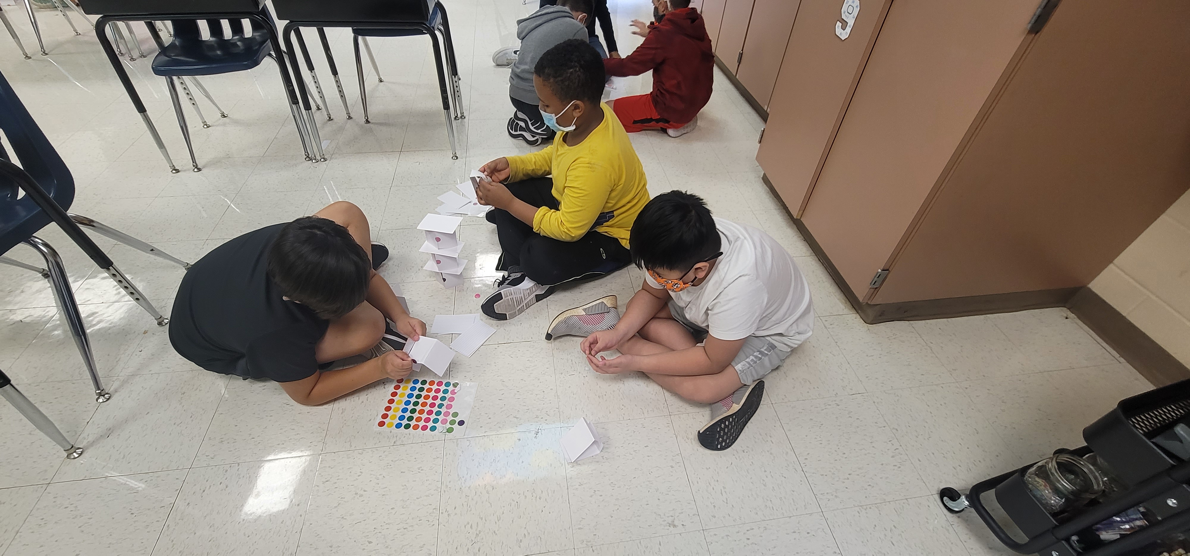 Students building a tower out of paper. 