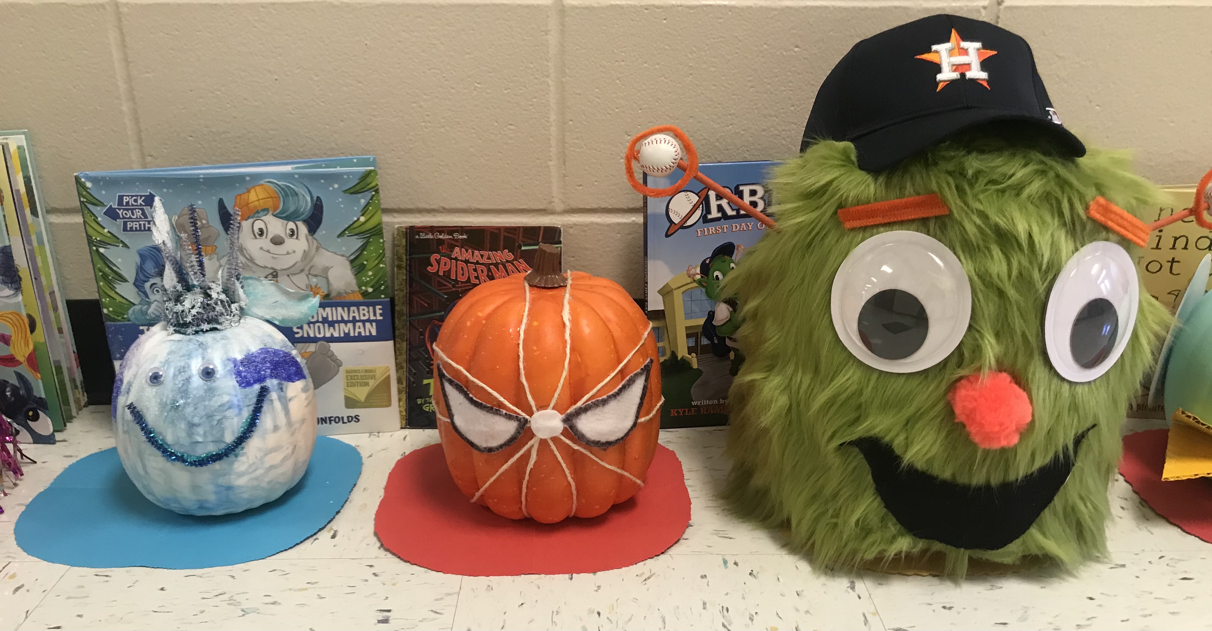 Pumpkins decorated like a snowman, Spiderman and Orbit