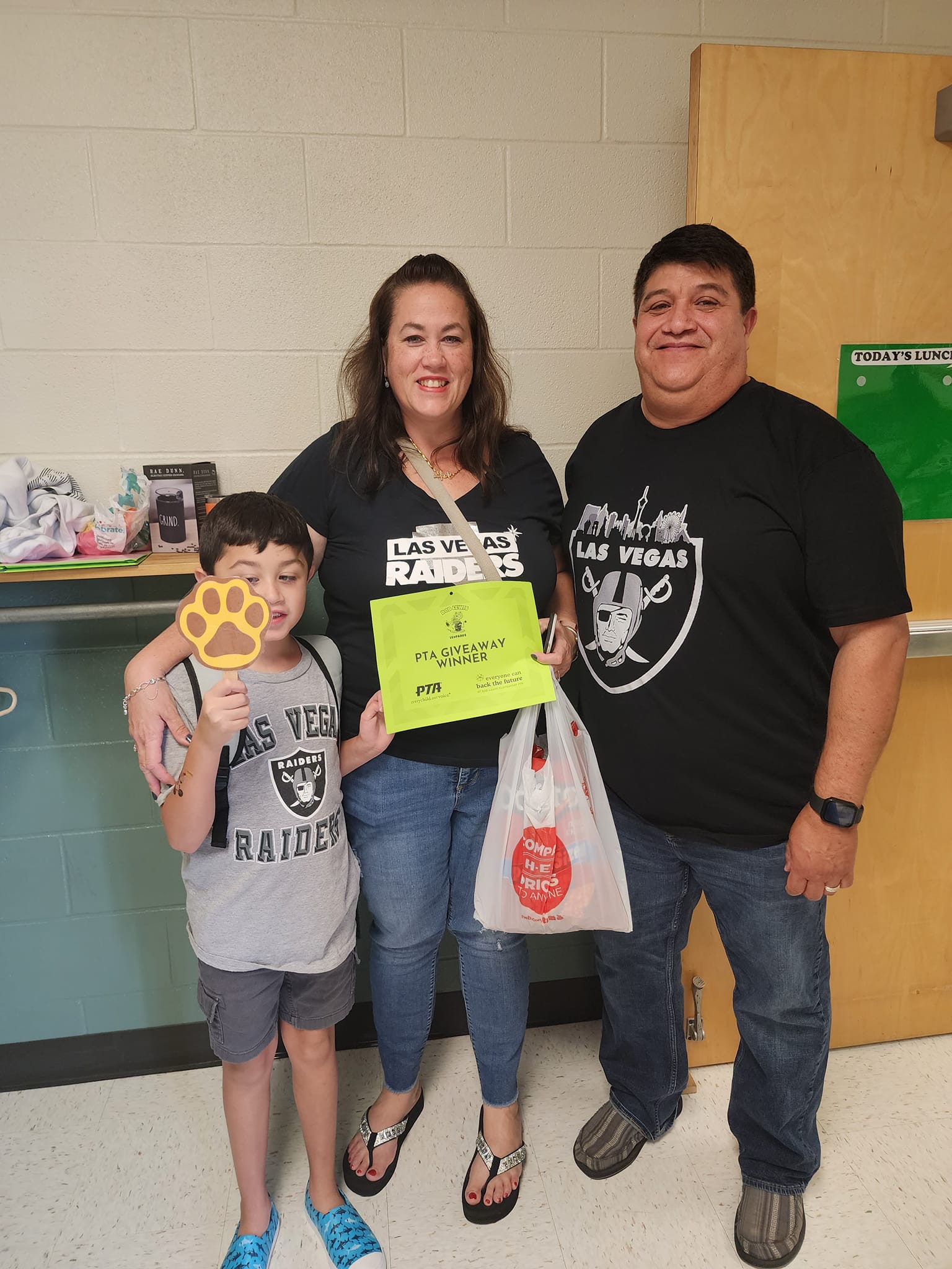 A dad, mom and child winning one of the PTA giveaways.