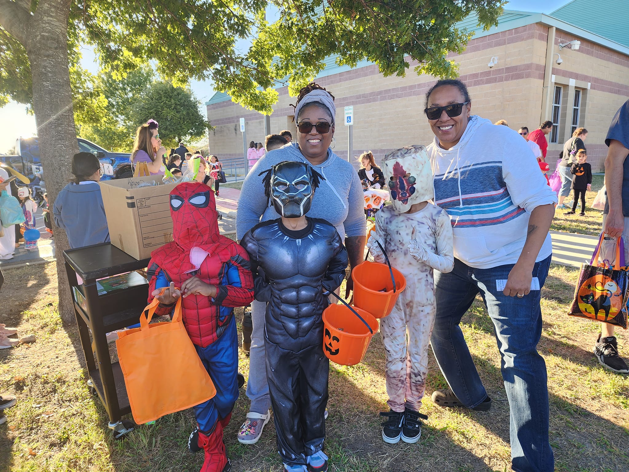 Family with children dresses in Spiderman and Black Panther costumes.