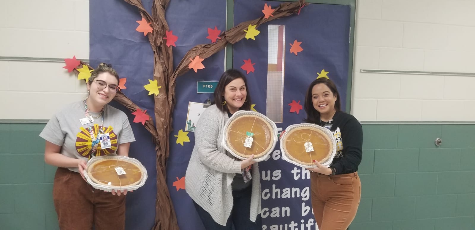 Three female Lewis staff showing there Thanksgiving pies from the PTA. 