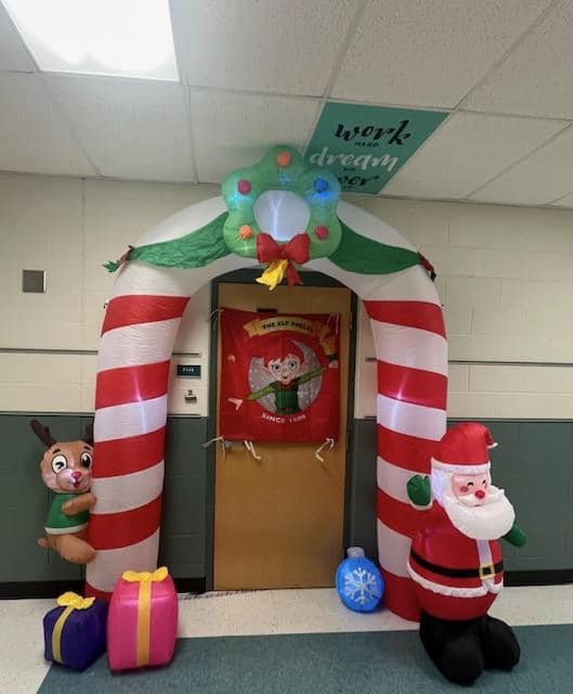A large blowup candy cane arch over the door to the Elf Shelf Holiday Store.