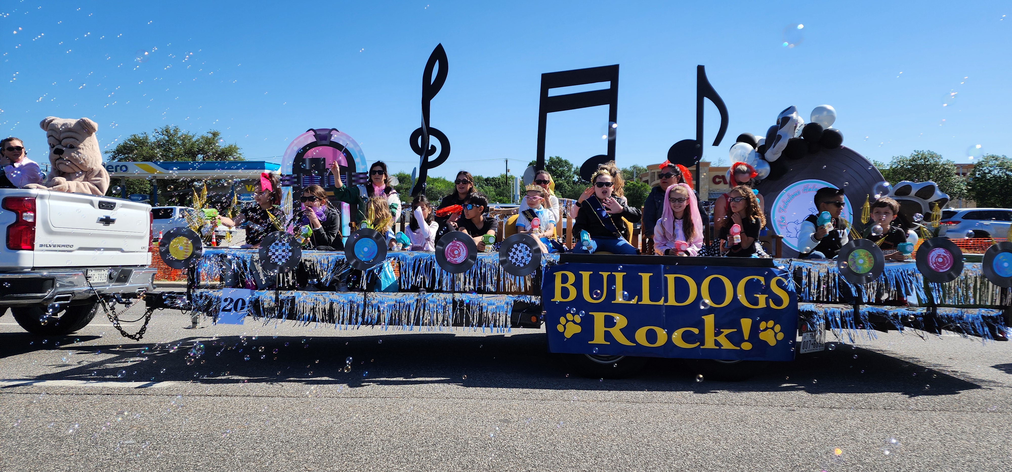 Pic of Helotes Cornyval Parade with students and staff on it speading bubbles and cheer
