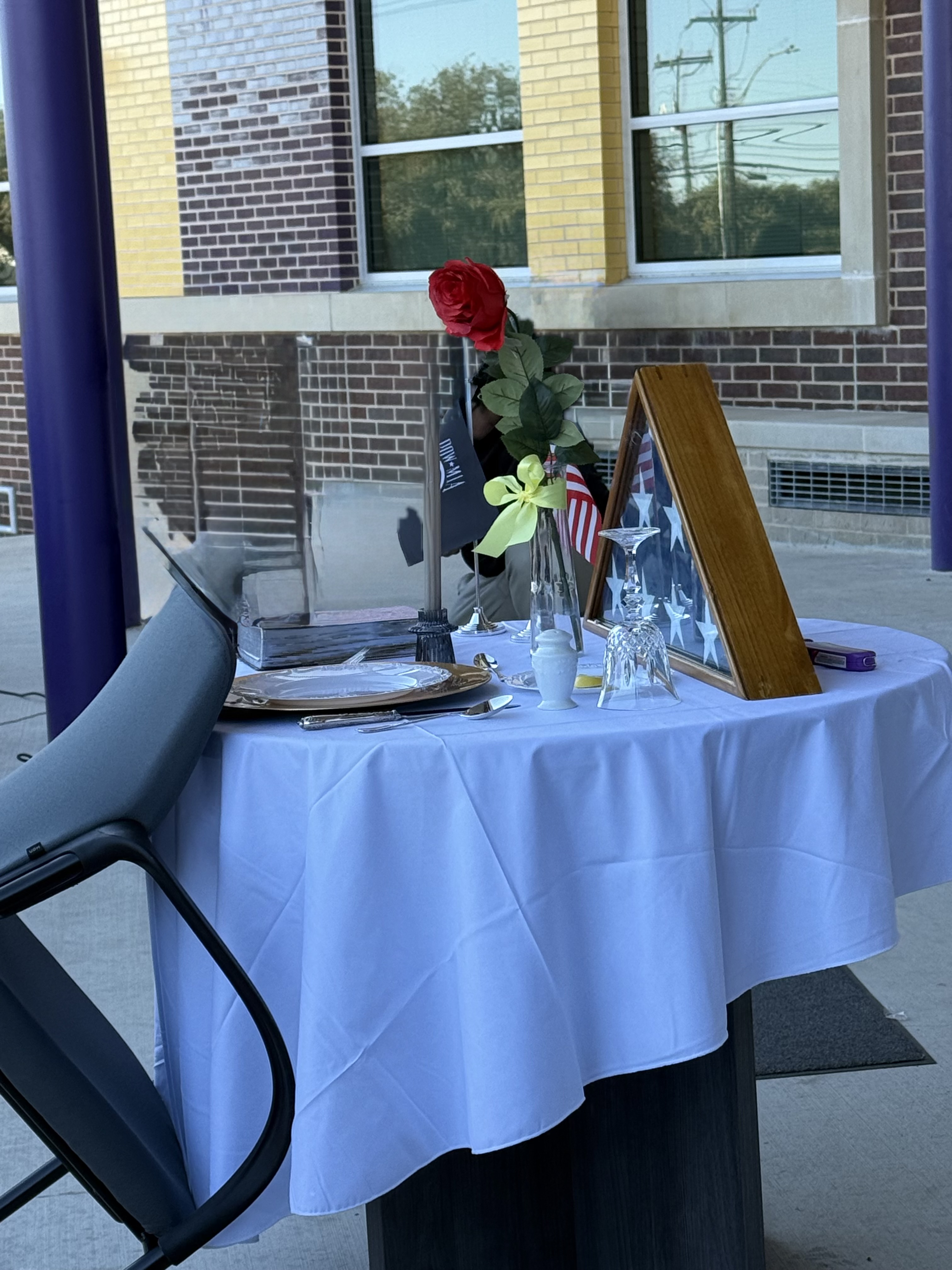picture of table with american flag in case, flowers and candles