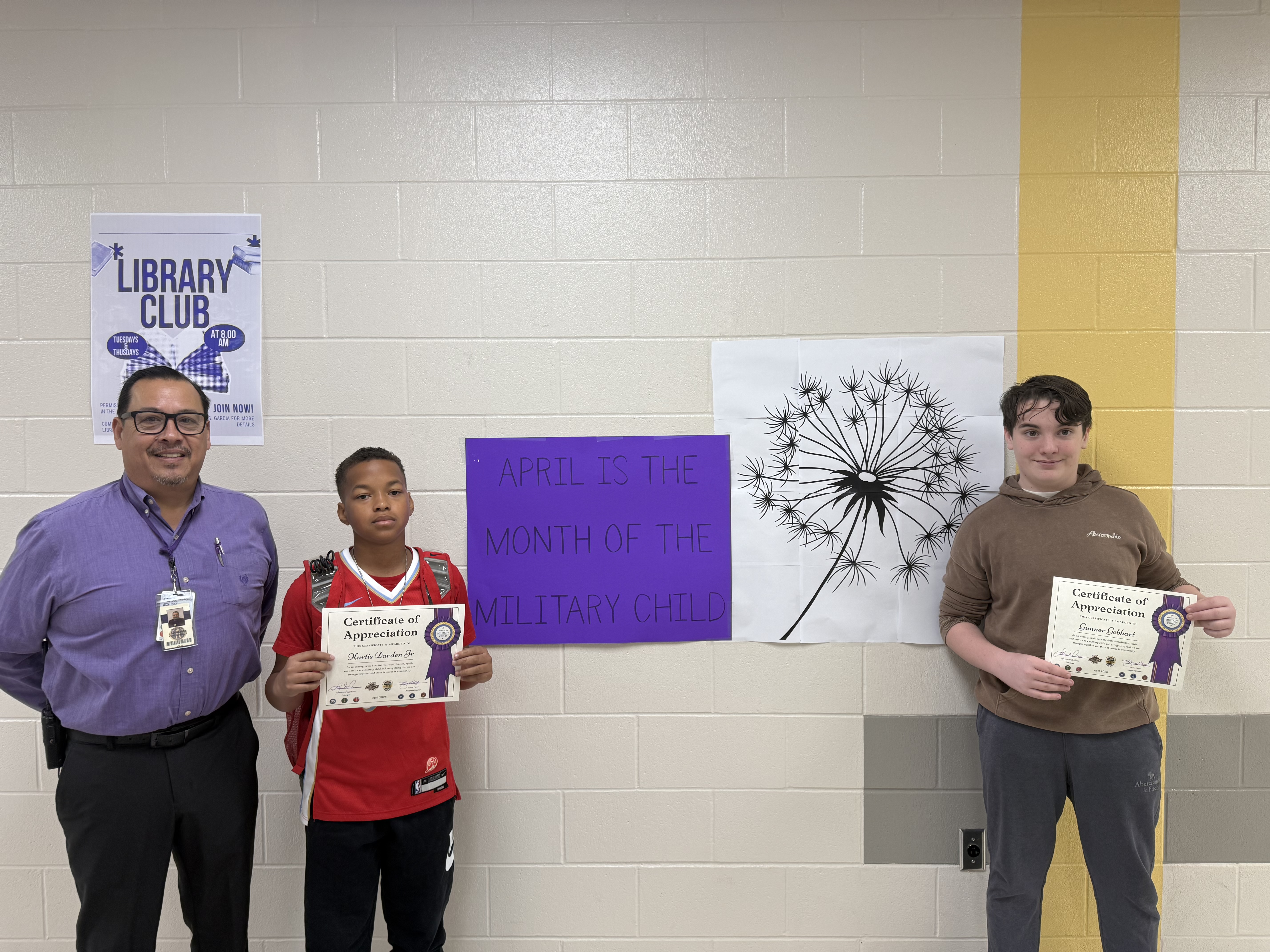 pIcture of Hobby principal next to students with certificates celebrating the month of the military child