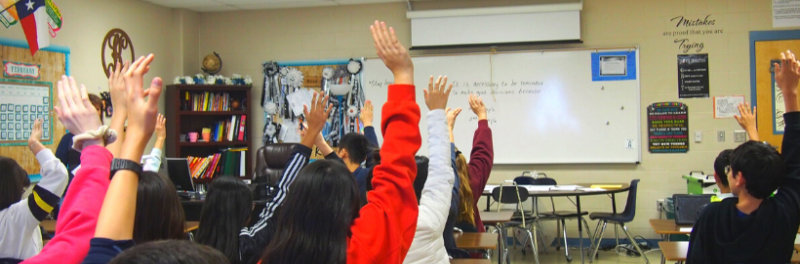 Students in Classroom Raising Their Hands