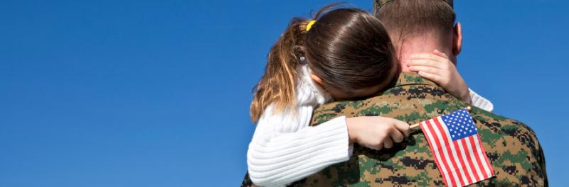 Image of military parent embracing child.