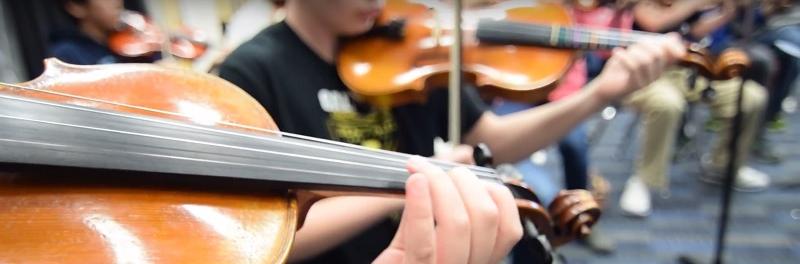A group of students playing instruments in orchestra