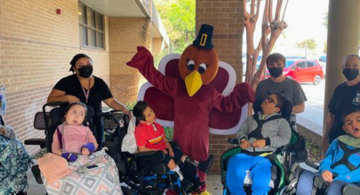 Reddix Staff and Students posing with a someone in a turkey costume