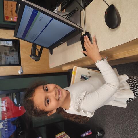 A student checking out her books.