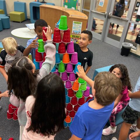 Students building a tower with cups during Makerspace Morning.