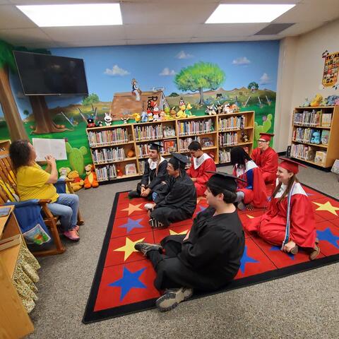 Mrs. Romero reading to Seniors at the Senior Walk