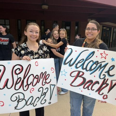 back to school Rawlinson Middle School two girls holding Welcome Back signs