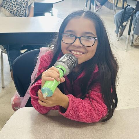 Student holding toy microphone