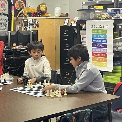 Students are shown playing chess. 