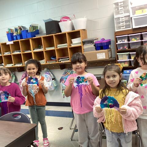 Student's holding their craft work. 