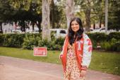 Lauren Gonzalez, Communications Arts graduate poses in letterman jacket