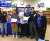 Students and VFW members pose with certificates in school library