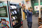 Billy holds up book he selected from book vending machine