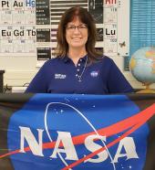 Teacher Kathleen Kraus holding NASA flag 