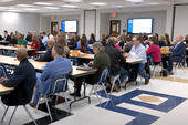 Photo from an NISD meeting. Room full of people attending. 
